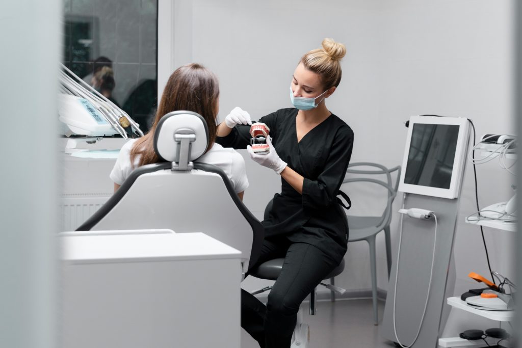 Das Bild zeigt eine Zahnärztin bei einer Prophylaxe Untersuchung bei einer Patientin